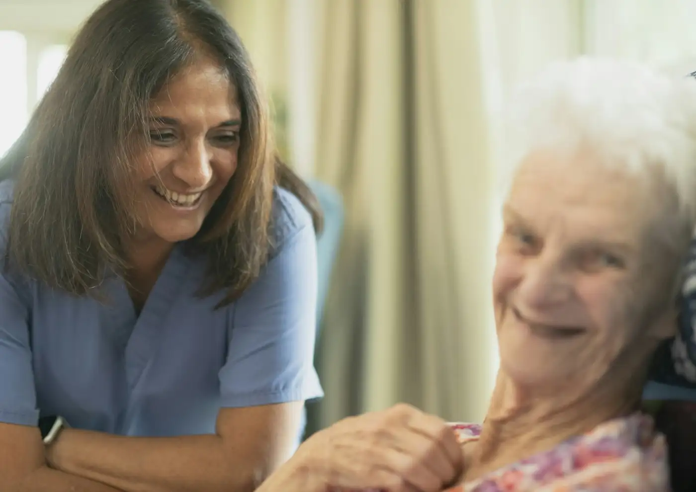 Smiling nurse talking with a senior patient